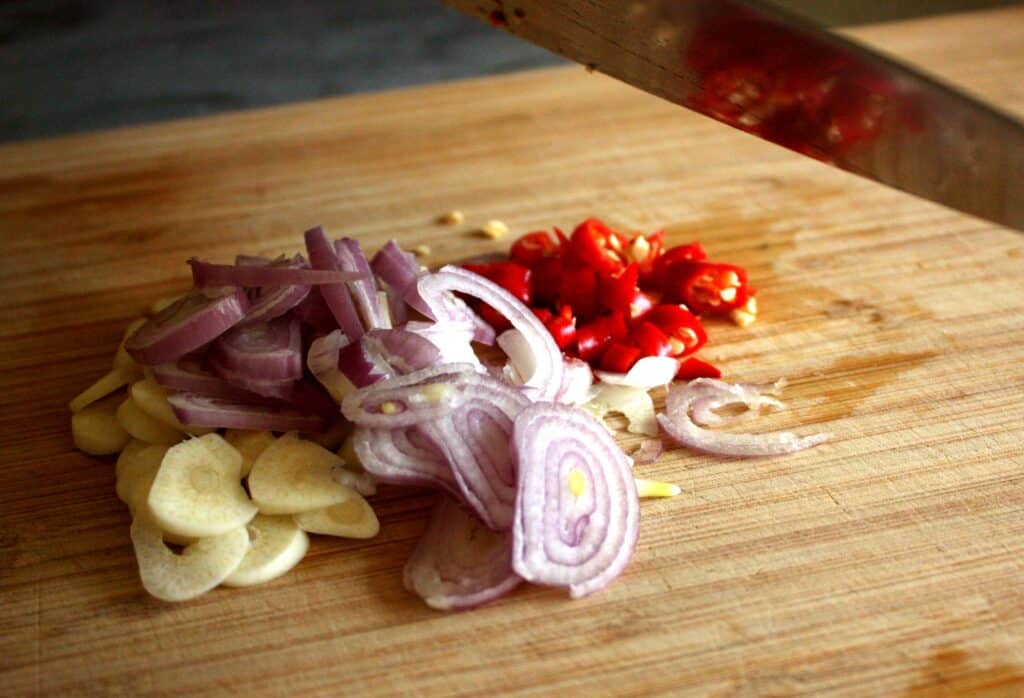 Garlic, shallots, and chillies on a cutting board
